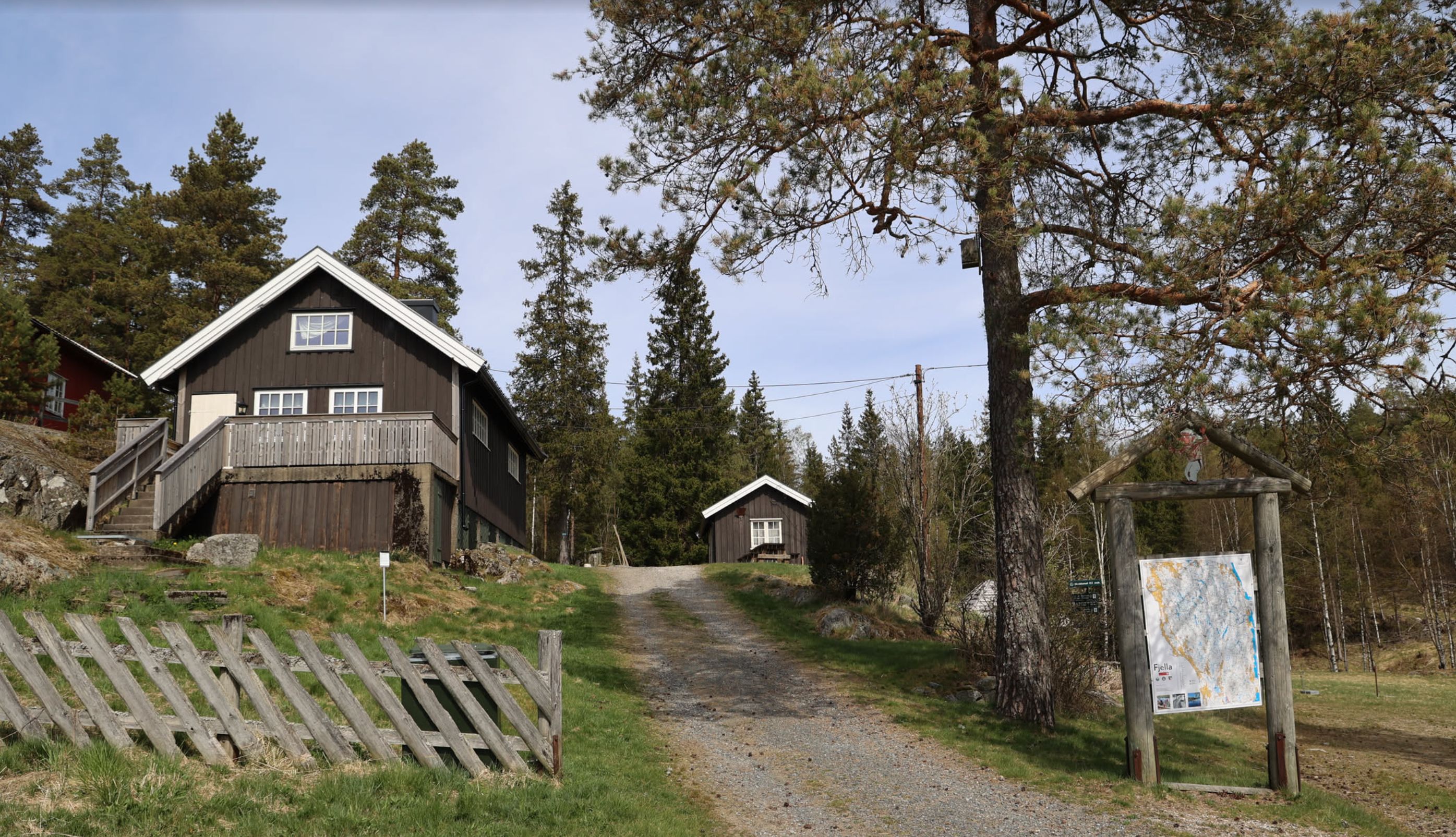 Fint bilde av hytten som viser hytten sydfra. I bakgrunnen kan vi se uthuset.